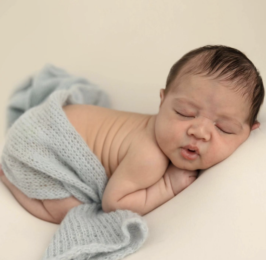 baby on blanket with blue wrap